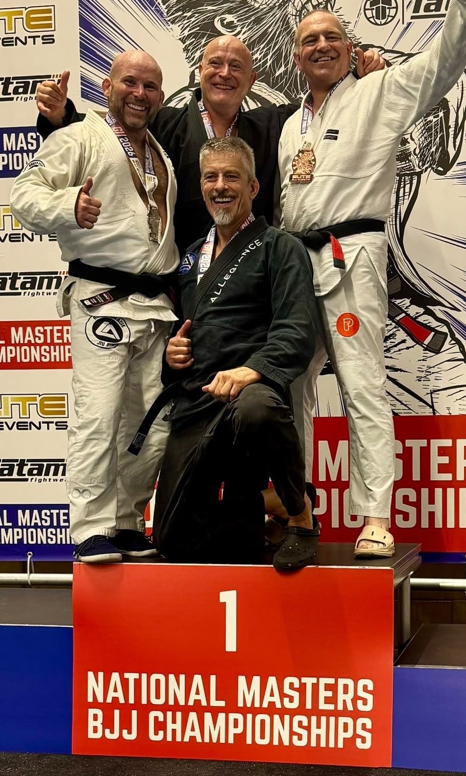 National Masters BJJ Championship medal winners celebrating together on the podium